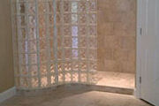 Pool House Bathroom with a Serpentine S Shaped Glass Block Shower Wall and Base Design