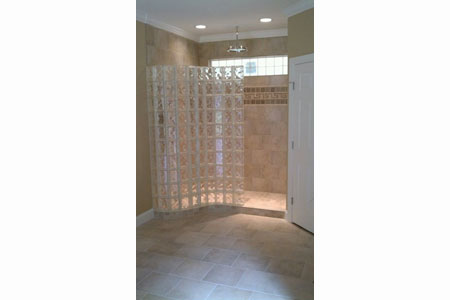 Pool House Bathroom with a Serpentine S Shaped Glass Block Shower Wall and Base Design