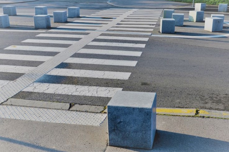 Here, “attention” pavers with domes guides walkers across the street: often “guidance” tile with long runners would be used instead.