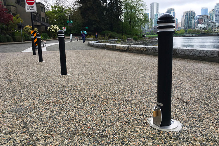 Fold-down shallow mount bollards control access to service or emergency lanes, parking areas, or other restricted locations.